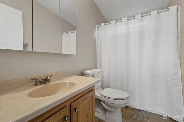a bathroom with a sink a toilet and a mirror
