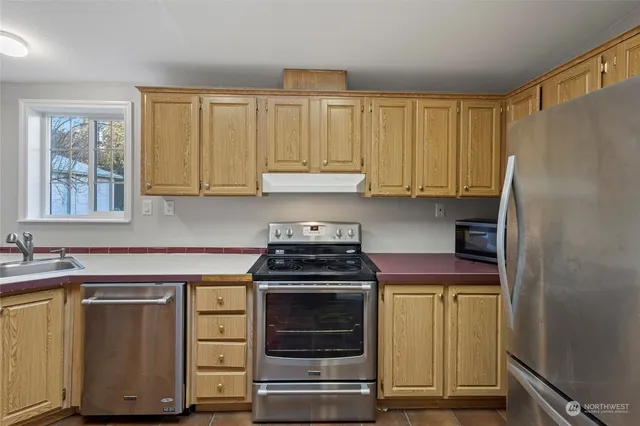 a kitchen with cabinets appliances and a window