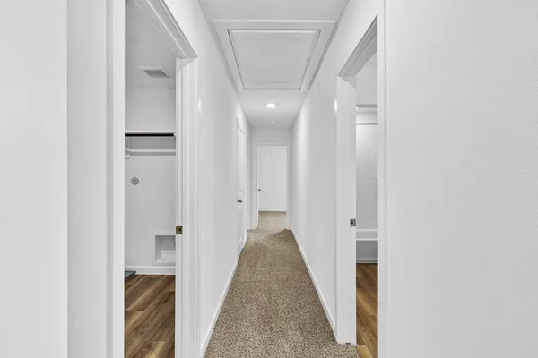 a view of a hallway with wooden floor and staircase
