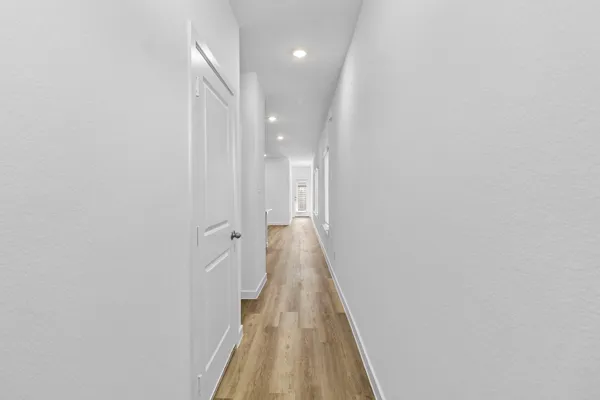 a view of a hallway with wooden floor and staircase