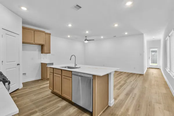 a kitchen with a sink and wooden floor