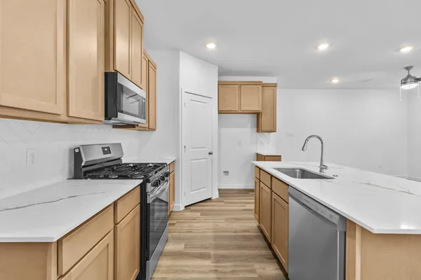 a kitchen with stainless steel appliances granite countertop a sink stove and cabinets