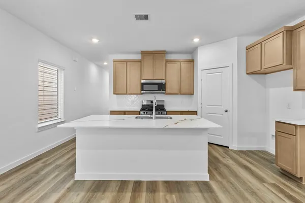 a view of kitchen with stainless steel appliances granite countertop a sink stove and refrigerator