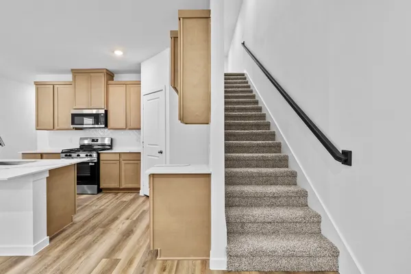 a kitchen with stainless steel appliances kitchen island wooden cabinets a stove and a sink