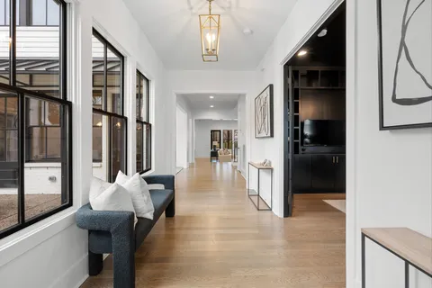a hallway with furniture and a large window