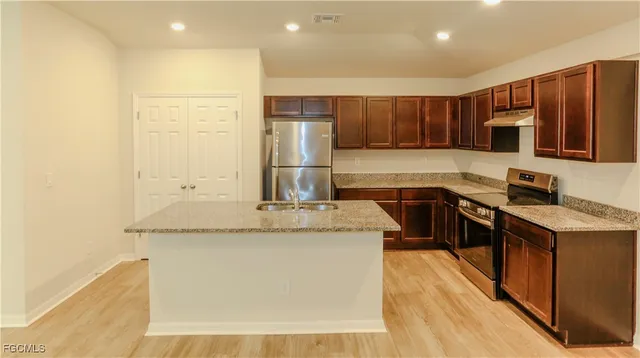 a kitchen with stainless steel appliances granite countertop a sink stove and refrigerator
