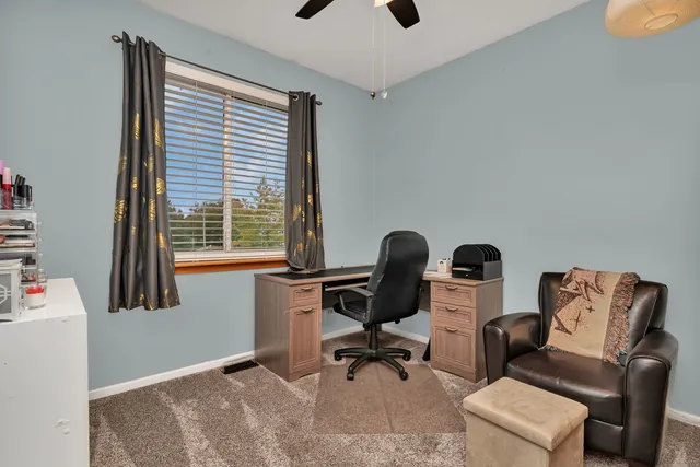 a view of a workspace with furniture and a window