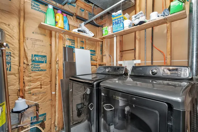 a utility room with stainless steel appliances a stove a refrigerator and a window