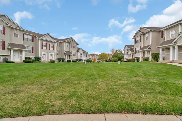 a view of a house with a big yard and large trees