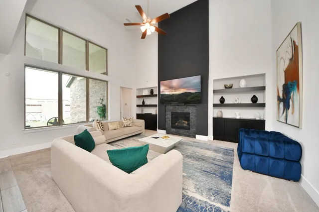 a living room with furniture kitchen view and a large window