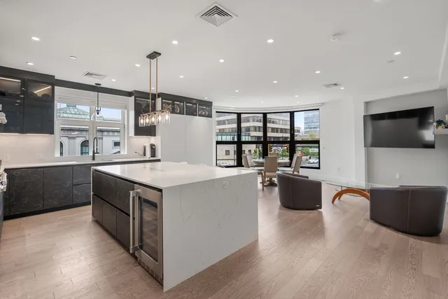 a kitchen with a stove a refrigerator and a television
