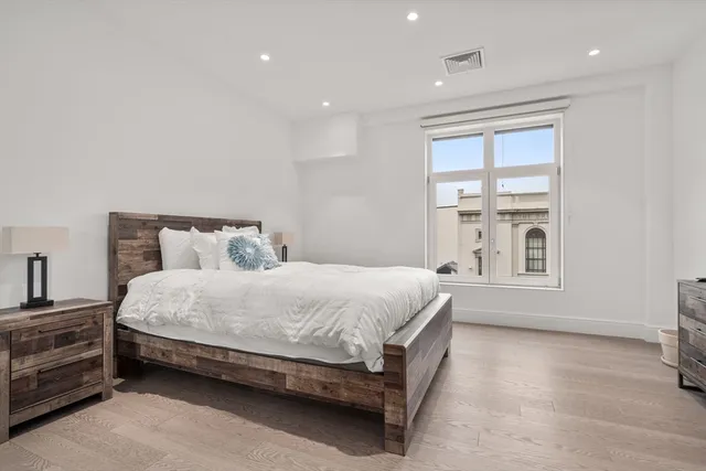 a spacious bedroom with a bed and a window