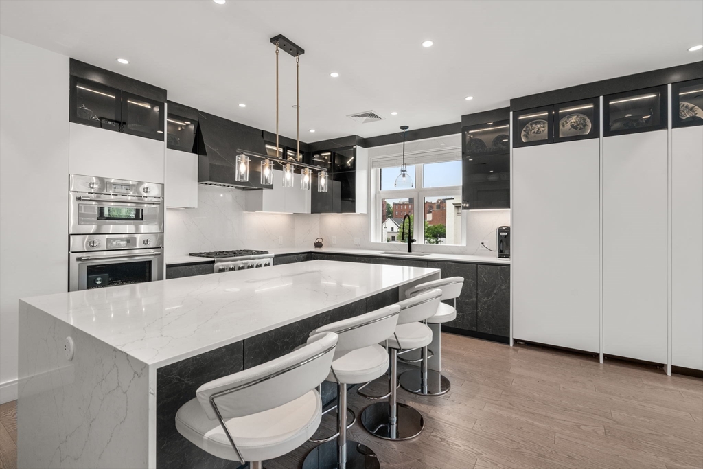 69 Walnut Street, Unit 4/5 Brookline, MA 02445 - Photo 3 of 26 a kitchen with a table chairs refrigerator and microwave