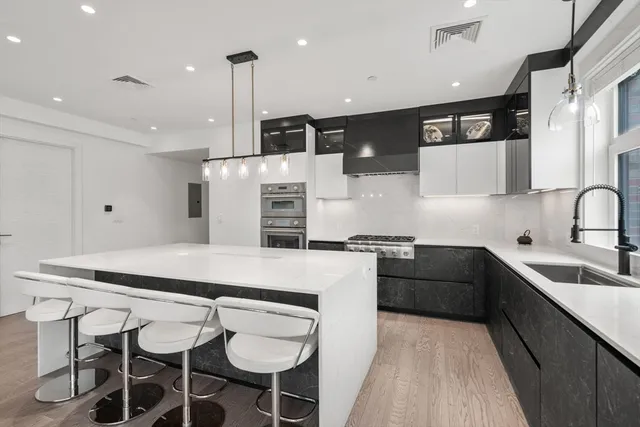 a kitchen with stainless steel appliances kitchen island granite countertop a sink and cabinets