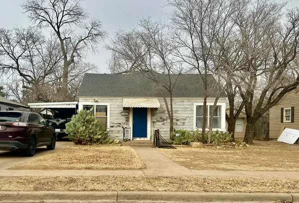 a view of a house with a yard and trees