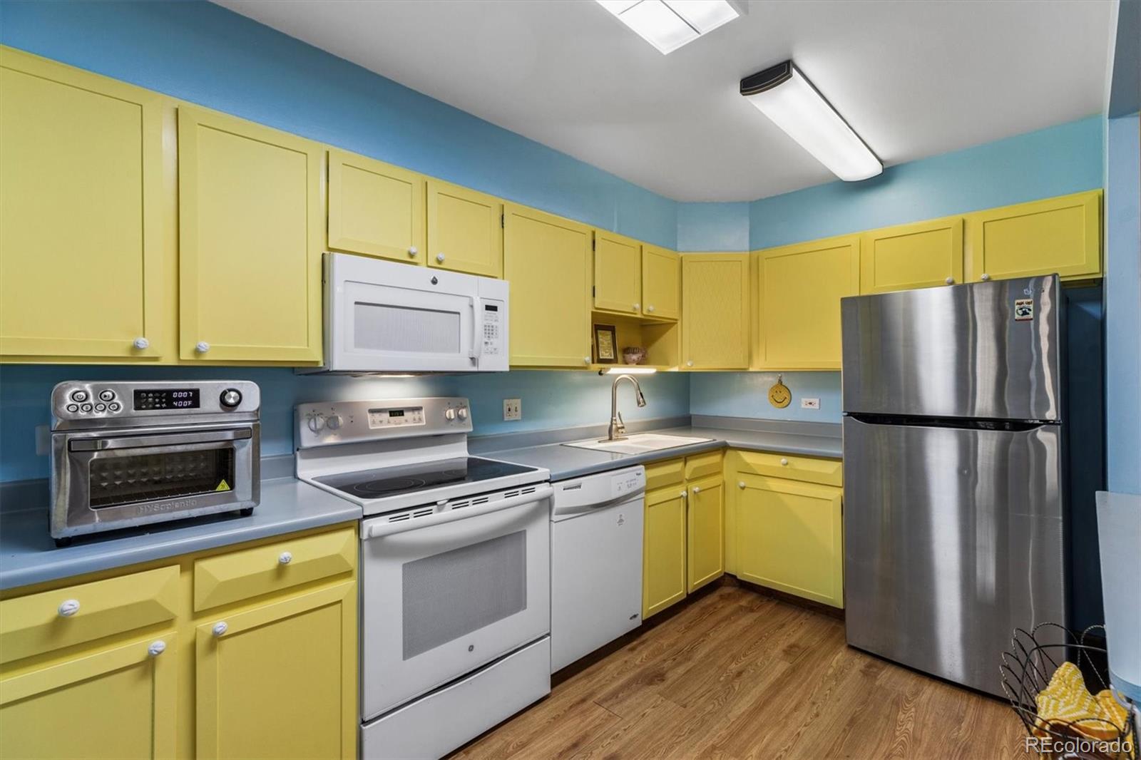 9155 Center Avenue, Unit 3B Denver, CO 80247 - Photo 2 of 50 a kitchen with a refrigerator sink and wooden cabinets