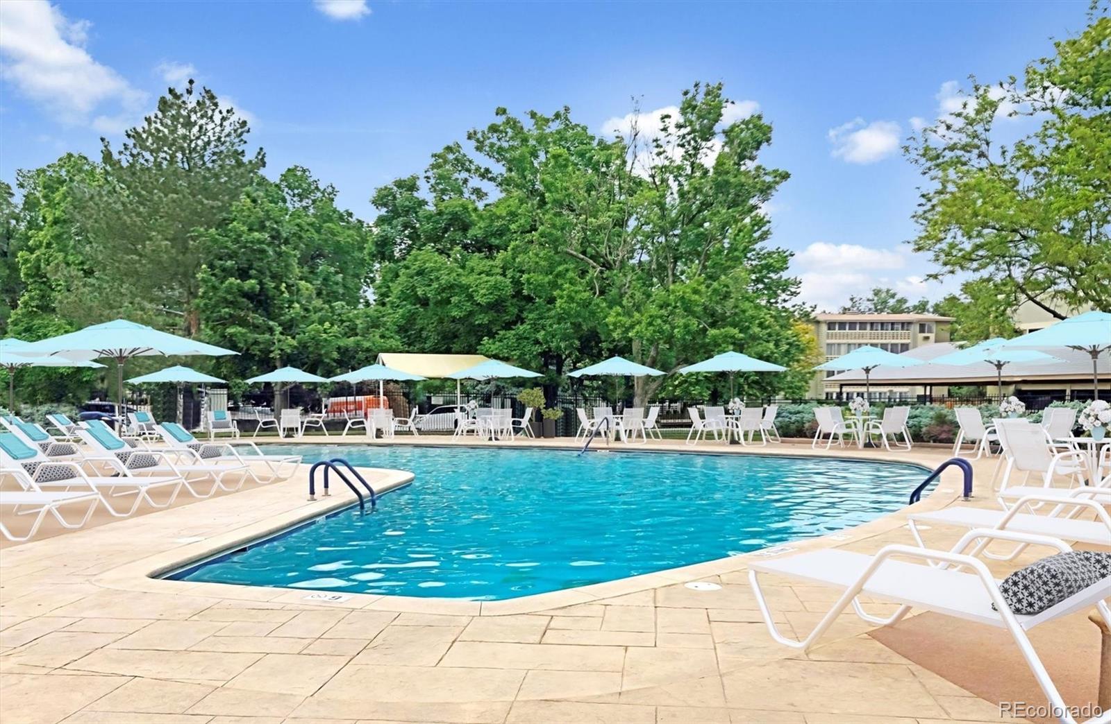 9155 Center Avenue, Unit 3B Denver, CO 80247 - Photo 29 of 50 a view of a swimming pool with a lawn chairs under an umbrella