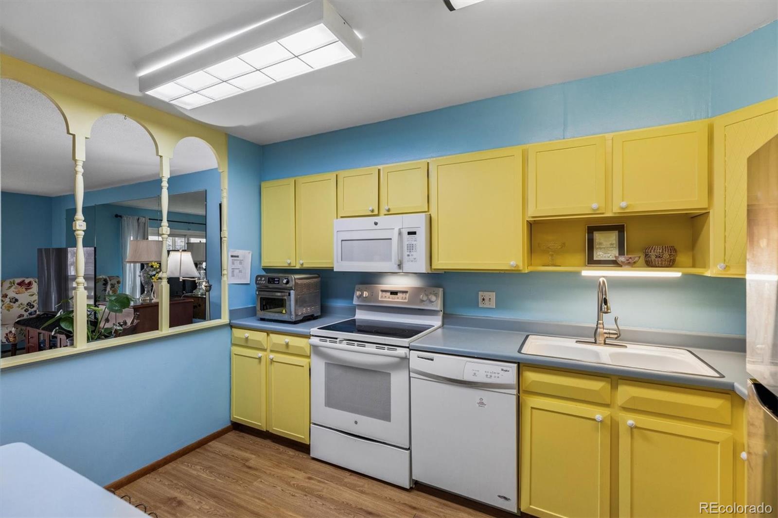 9155 Center Avenue, Unit 3B Denver, CO 80247 - Photo 5 of 50 a kitchen with a sink cabinets and wooden floor