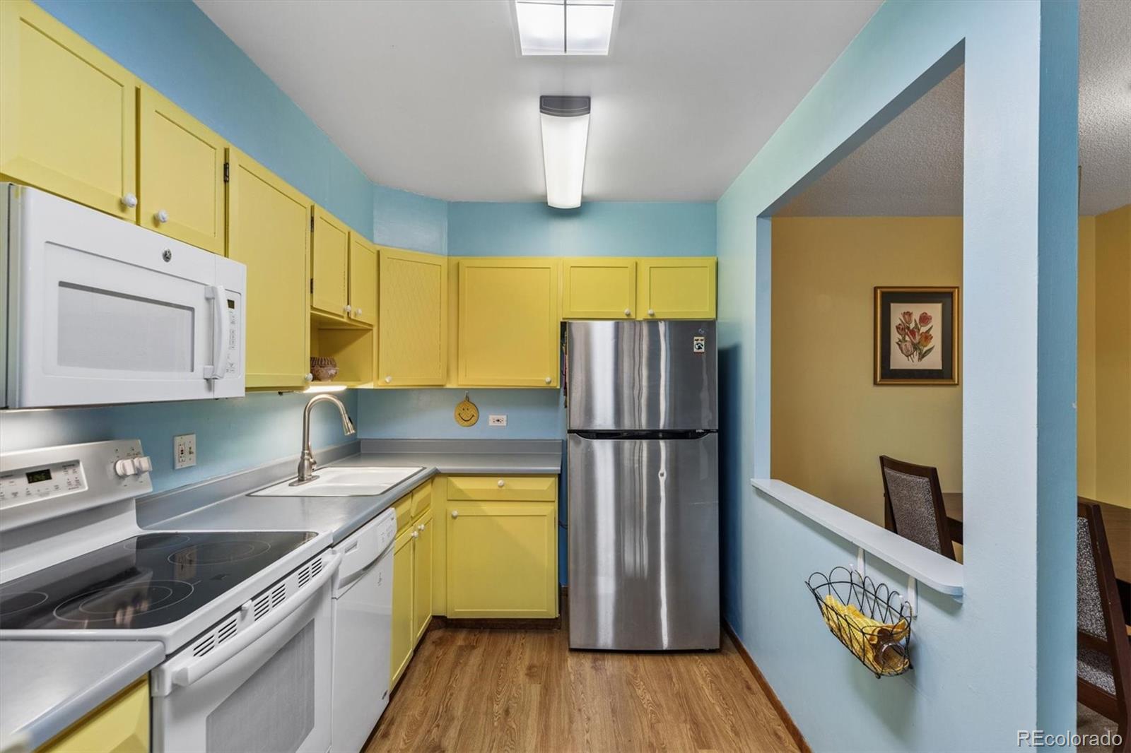9155 Center Avenue, Unit 3B Denver, CO 80247 - Photo 9 of 50 a kitchen with a refrigerator a stove and wooden floor