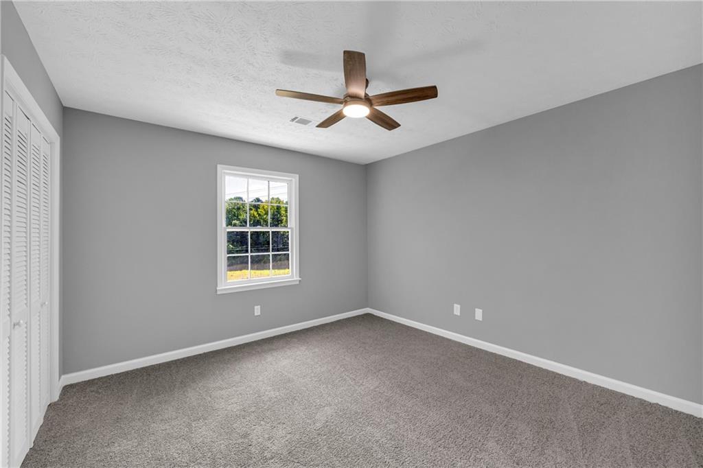 4872 Arrowhead Trail W Southwest Lilburn, GA 30047 - Photo 22 of 44 an empty room with a window and a fan