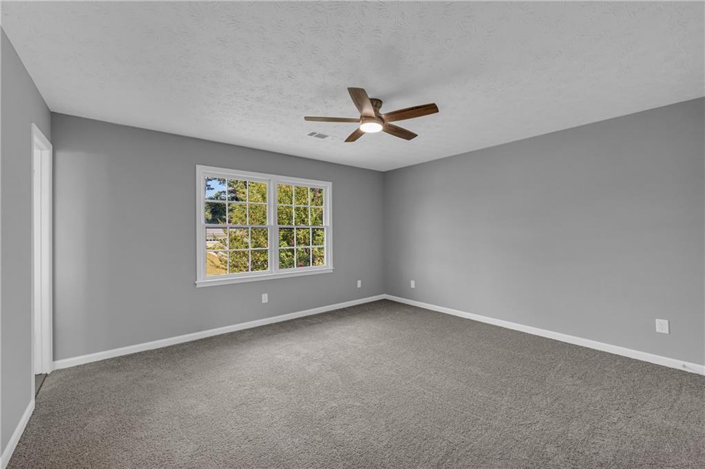 4872 Arrowhead Trail W Southwest Lilburn, GA 30047 - Photo 26 of 44 a view of room with a ceiling fan and window
