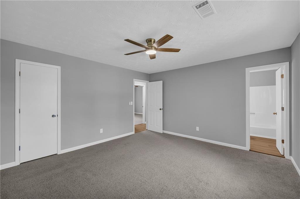 4872 Arrowhead Trail W Southwest Lilburn, GA 30047 - Photo 28 of 44 an empty room with closet and a ceiling fan
