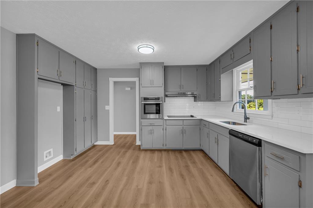 4872 Arrowhead Trail W Southwest Lilburn, GA 30047 - Photo 10 of 44 a kitchen with granite countertop a stove top oven sink and cabinets