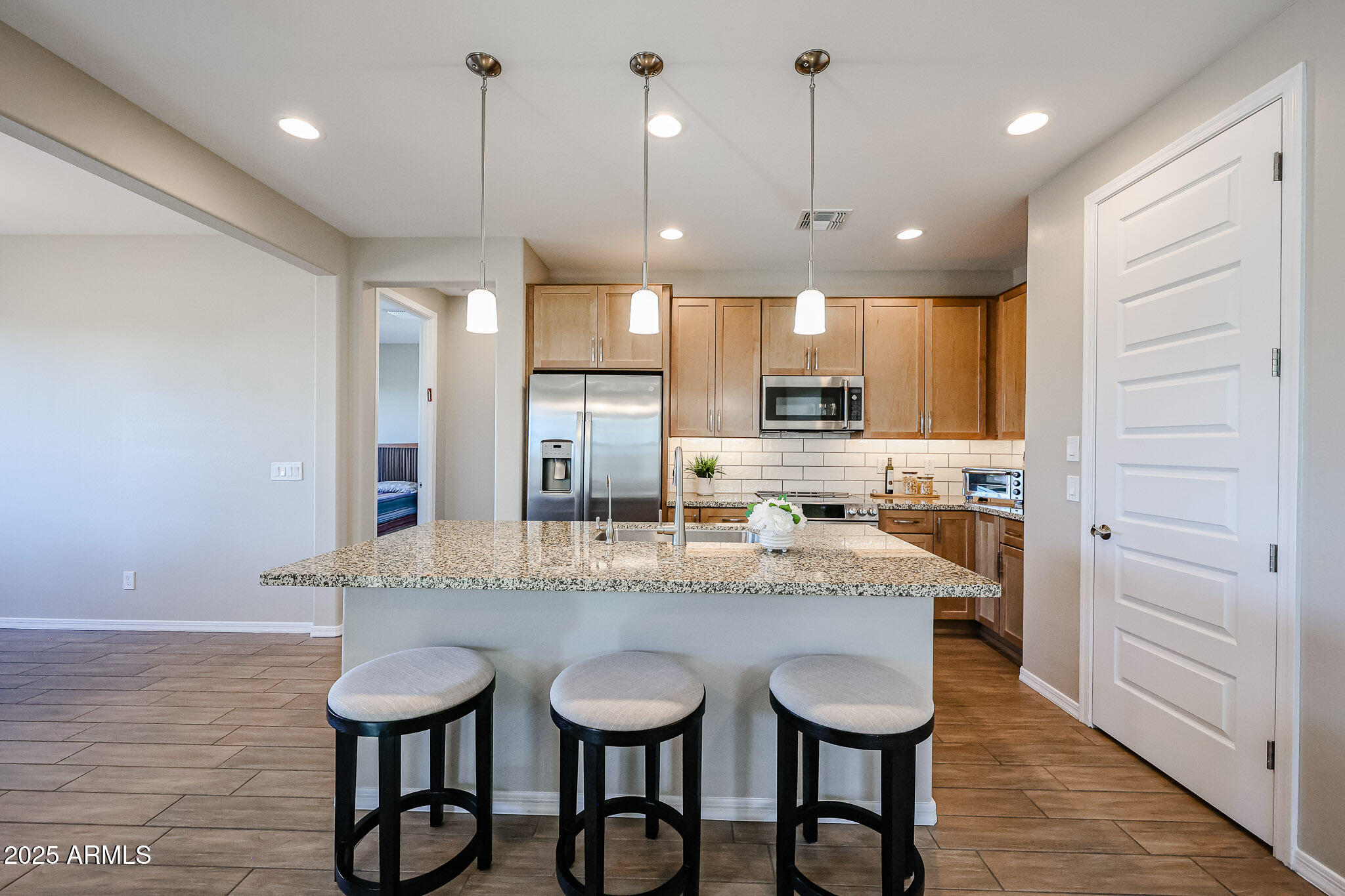 18062 West Amber Ridge Way Goodyear, AZ 85338 - Photo 6 of 67 a kitchen with kitchen island granite countertop a sink a counter space stainless steel appliances and cabinets