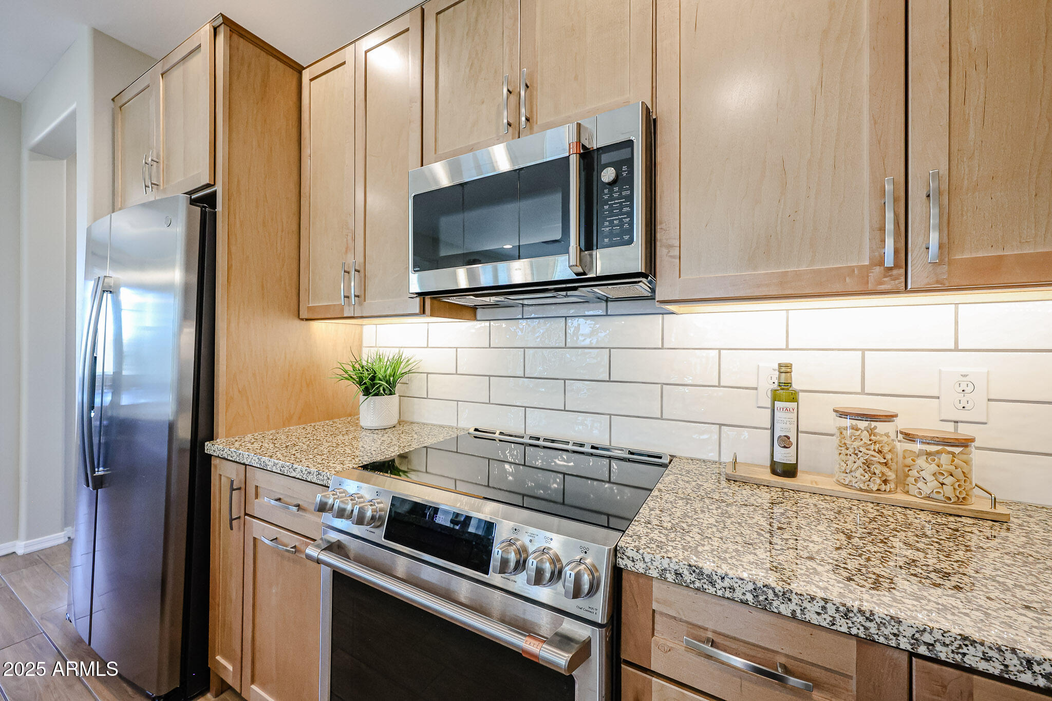 18062 West Amber Ridge Way Goodyear, AZ 85338 - Photo 9 of 67 a kitchen with granite countertop a sink stove and refrigerator