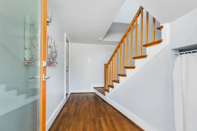 a view of a hallway with wooden floor and staircase