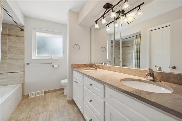 a spacious bedroom with a bed and wooden floor