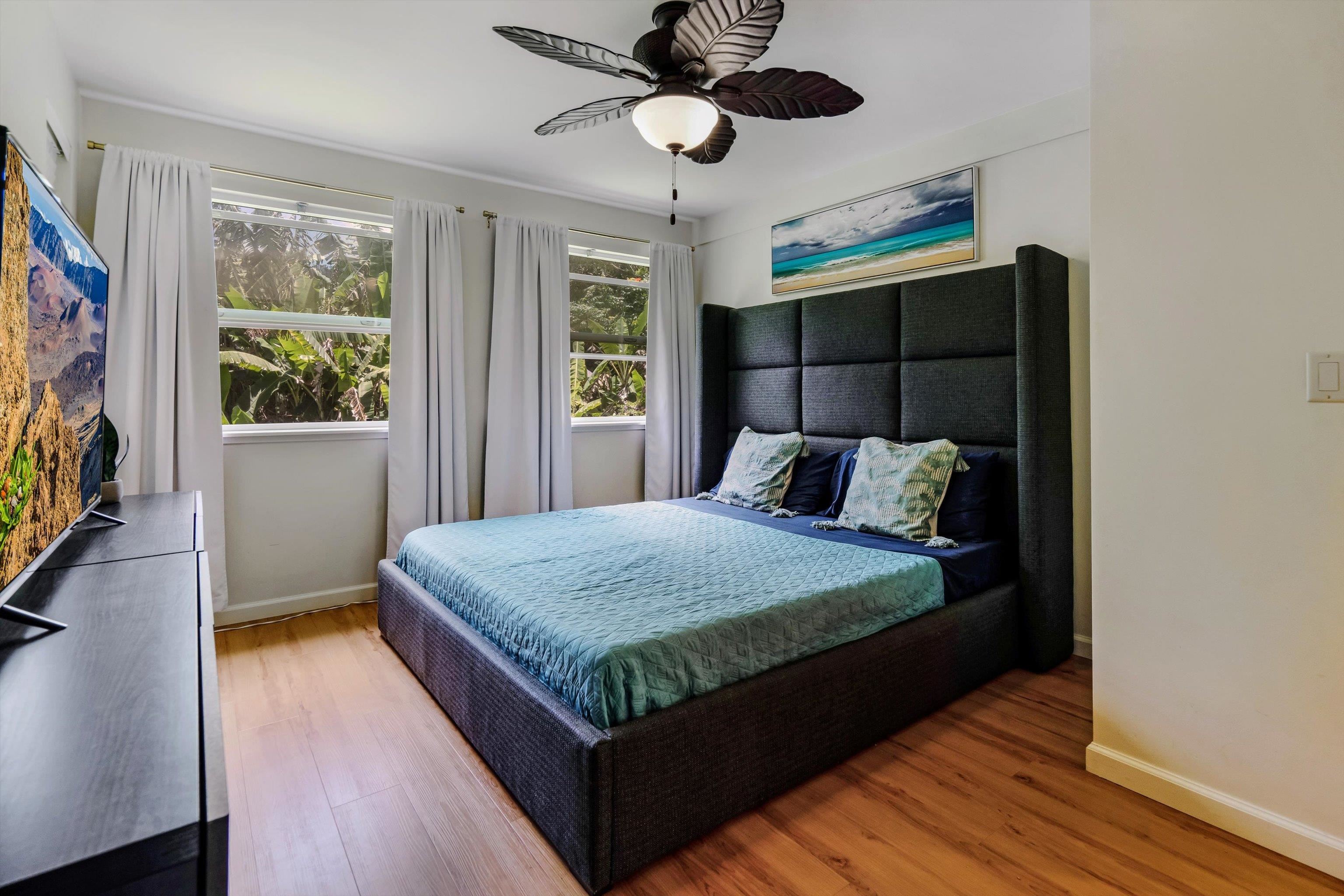 303 Waipalani Road Haiku, HI 96708 - Photo 14 of 46 a bedroom with a bed and a flat tv screen on dresser