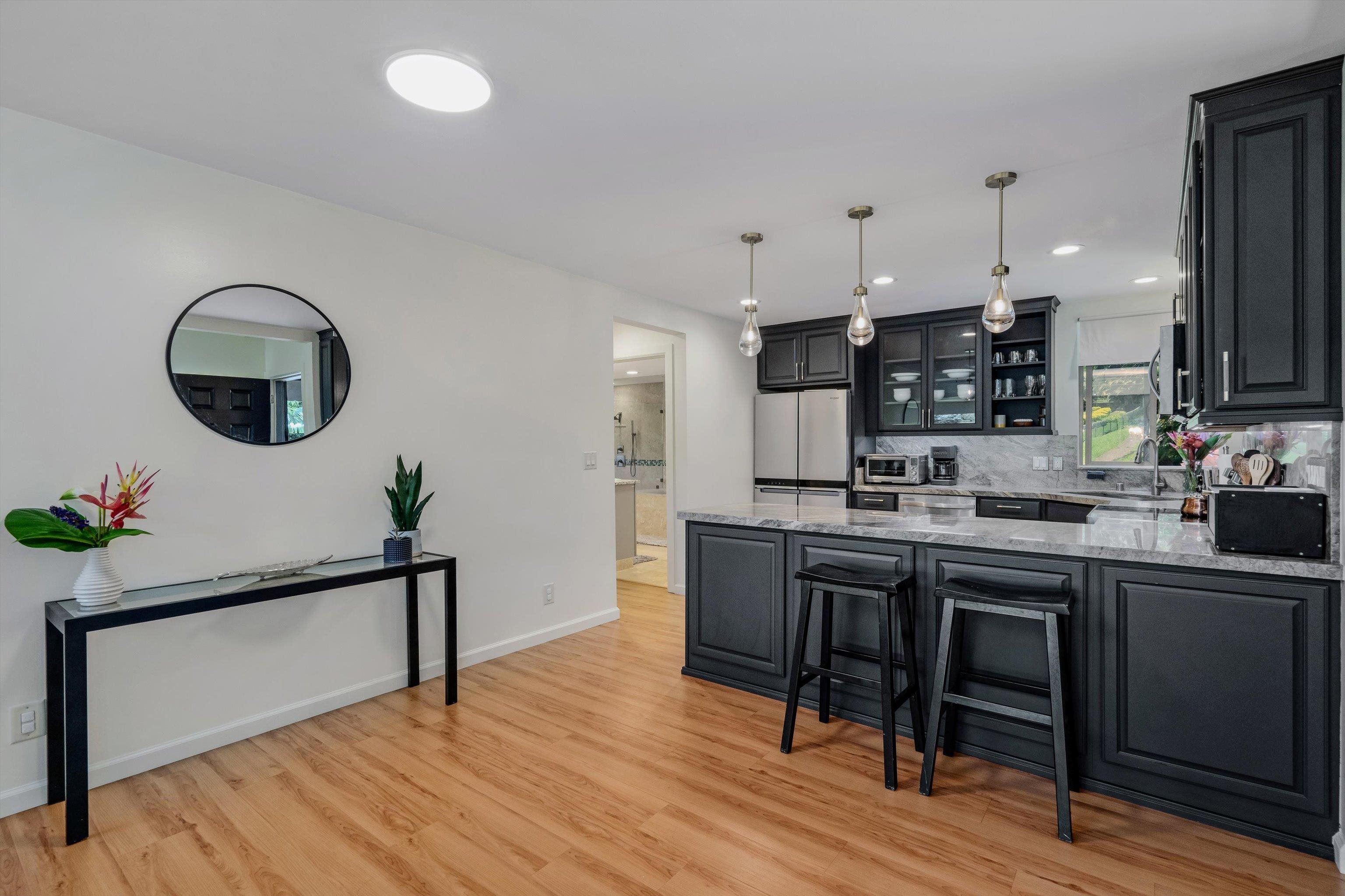 303 Waipalani Road Haiku, HI 96708 - Photo 17 of 46 a kitchen with kitchen island a dining table chairs sink and cabinets