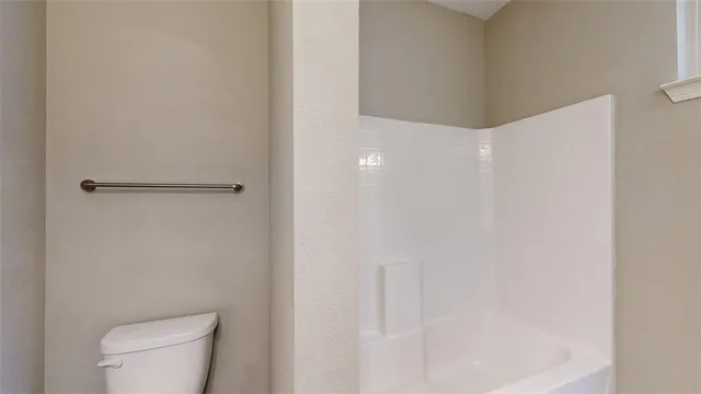 a white toilet sitting next to a shower