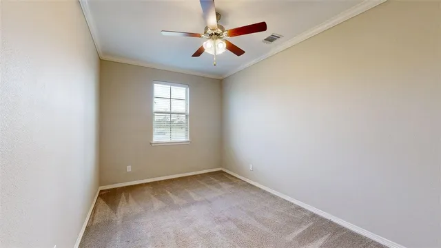 an empty room with a window and a ceiling fan