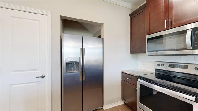a kitchen with stainless steel appliances a stove microwave and refrigerator
