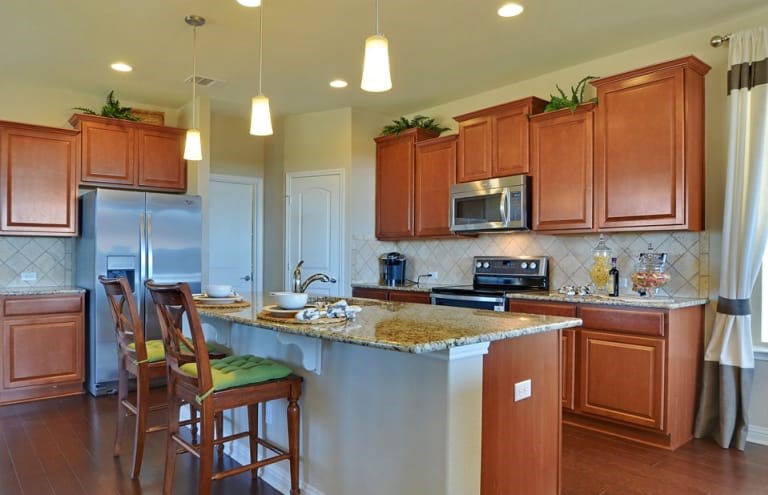 16017 Travesia Way Austin, TX 78728 - Photo 4 of 12 a kitchen with a sink a microwave a stove and cabinets
