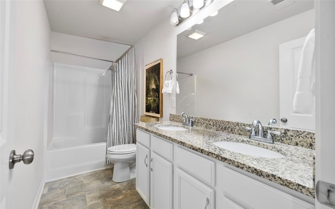 221 Scenic Drive Anderson, SC 29621 - Photo 20 of 27 This bathroom features a double vanity with granite counters and a combination bathtub and shower.