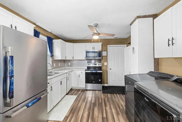 a kitchen with granite countertop a refrigerator stove and sink