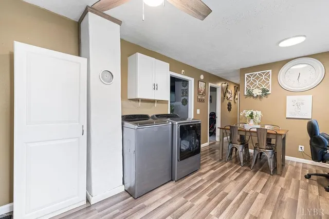 a kitchen with stainless steel appliances granite countertop a stove top oven a refrigerator a dining table and chairs with wooden floor