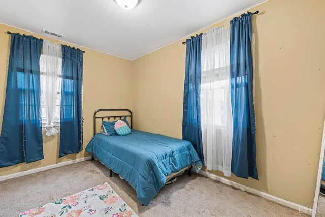 a bedroom with a bed and a window