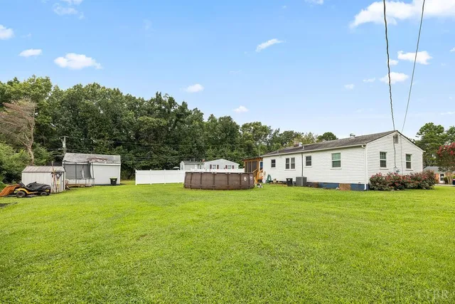 a view of a house with a big yard and large trees