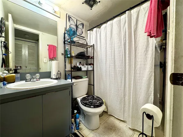 a bathroom with a sink mirror toilet and window