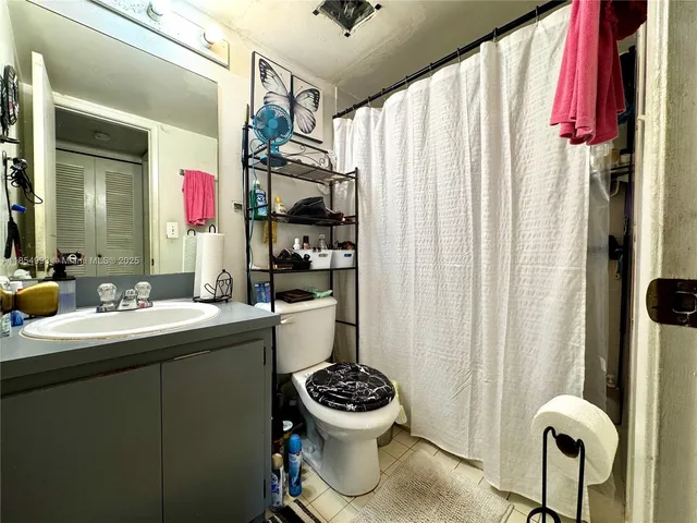 a bathroom with a sink mirror toilet and window