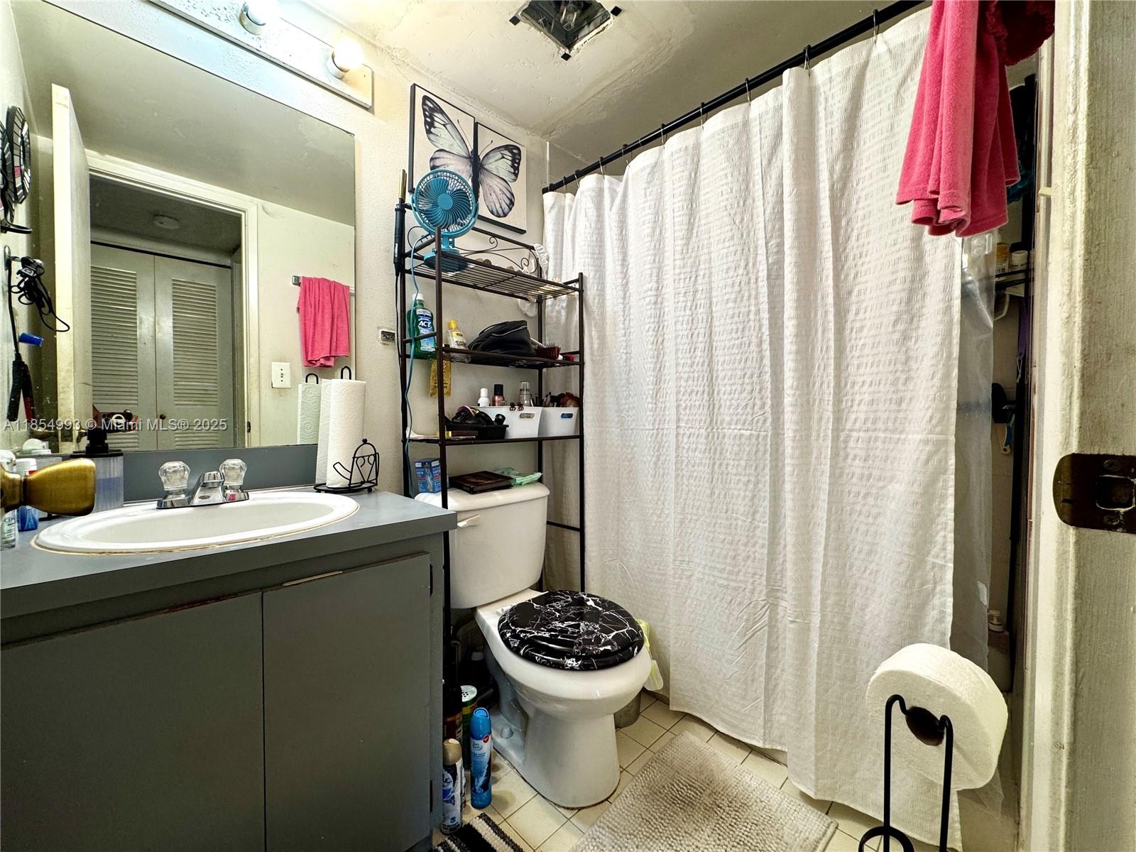 7165 Northwest 186th Street, Unit A211 Hialeah, FL 33015 - Photo 8 of 15 a bathroom with a sink mirror toilet and window