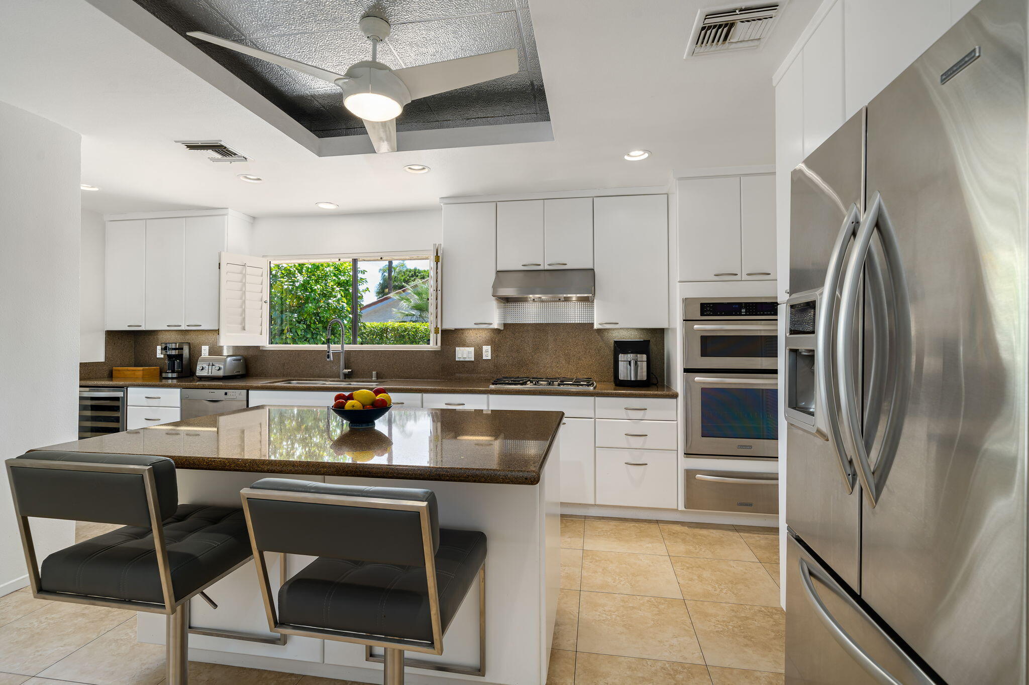 41 Lincoln Place Rancho Mirage, CA 92270 - Photo 16 of 37 a kitchen with stainless steel appliances granite countertop a refrigerator a stove a sink dishwasher a dining table and chairs with wooden floor
