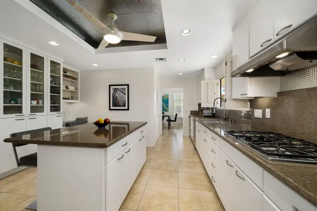 a kitchen with stainless steel appliances granite countertop a sink stove and cabinets