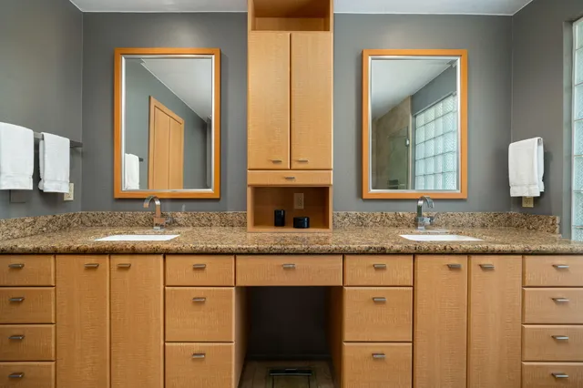 a bathroom with a granite countertop sink vanity and mirror