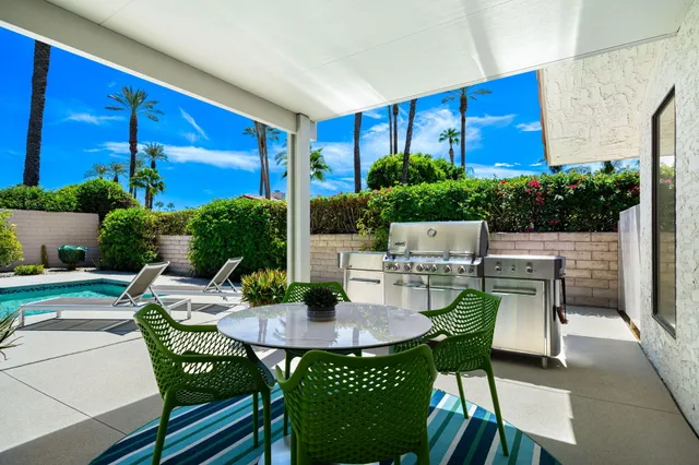 a view of an outdoor dining space with a table and chairs