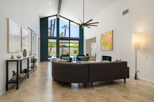a living room with furniture a flat screen tv and a window